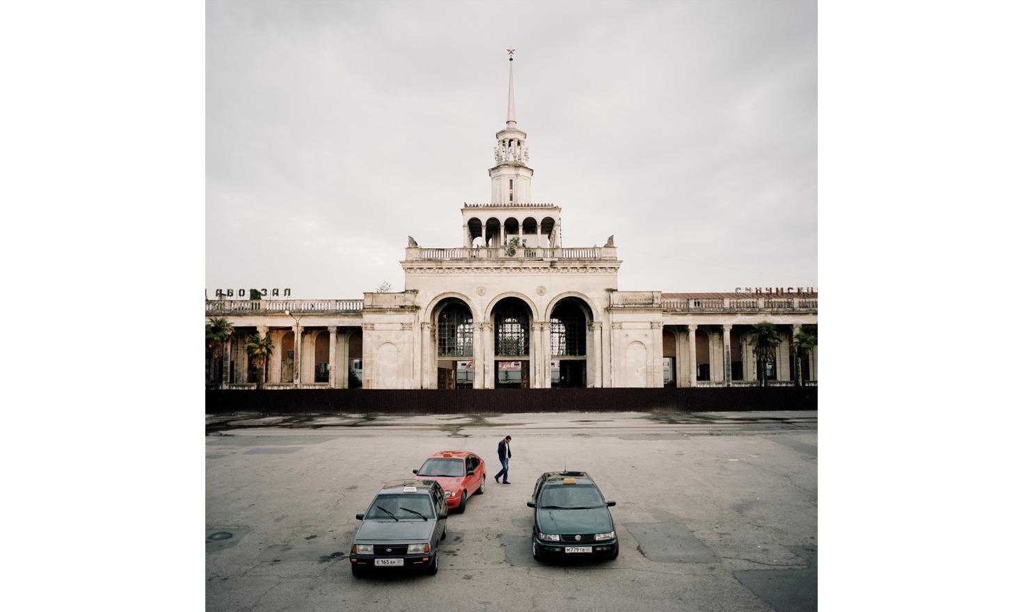 A man walk in front of the Sukhum(i) train station which is under renovation.