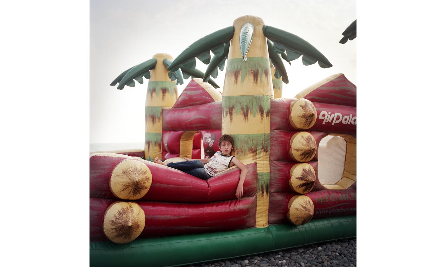 A young boy on a bouncy castle on Sukhum(i) Beach.