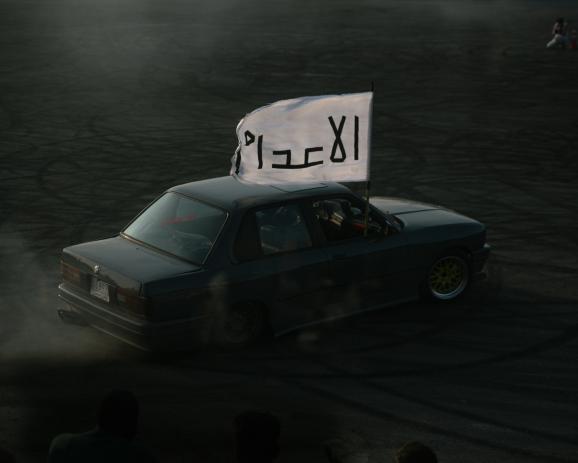 One of the contestants races on the track while displaying the name of his team on a flag: the Executioners