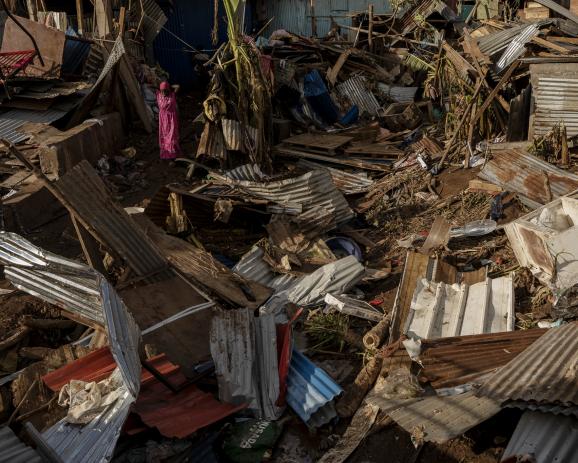 Une femme marche parmis les décombres à Kaweni, plus grand bidonville de France, après le passage du cyclone Chido, à Mayotte, archipel de l'océan indien et département français d'outremer au large de l'Afrique,  le 19 décembre 2024.