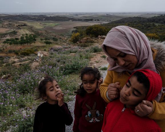 Samira, 37 ans, ses enfants et ceux des voisins, devant sa maison qui surplombe le barrage de Chiba, au le Cap Bon, en Tunisie, le 20 avril 2023. Samira dit que c'est la première année qu'elle voit le barrage aussi sec. « Avant, quand il pleuvait, c'était