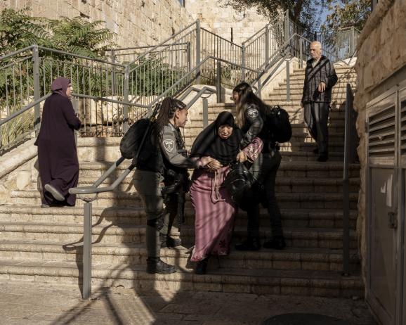 Une vieille dame qui était assise dans des escaliers juste à l'extérieur de la porte Lion se fait chasser par des policières israéliennes. Le vendredi, l'accès à la vieille ville de Jérusalem est restreint depuis le début de la guerre Israël-Hamas, Israël